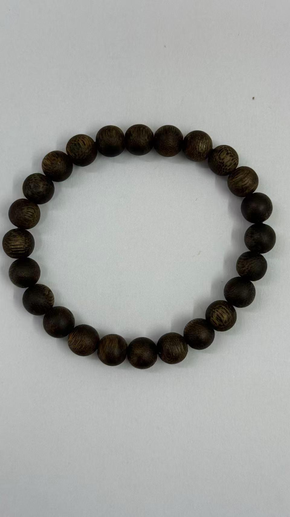 Dark agarwood bead bracelet with fine wood grain on a white background