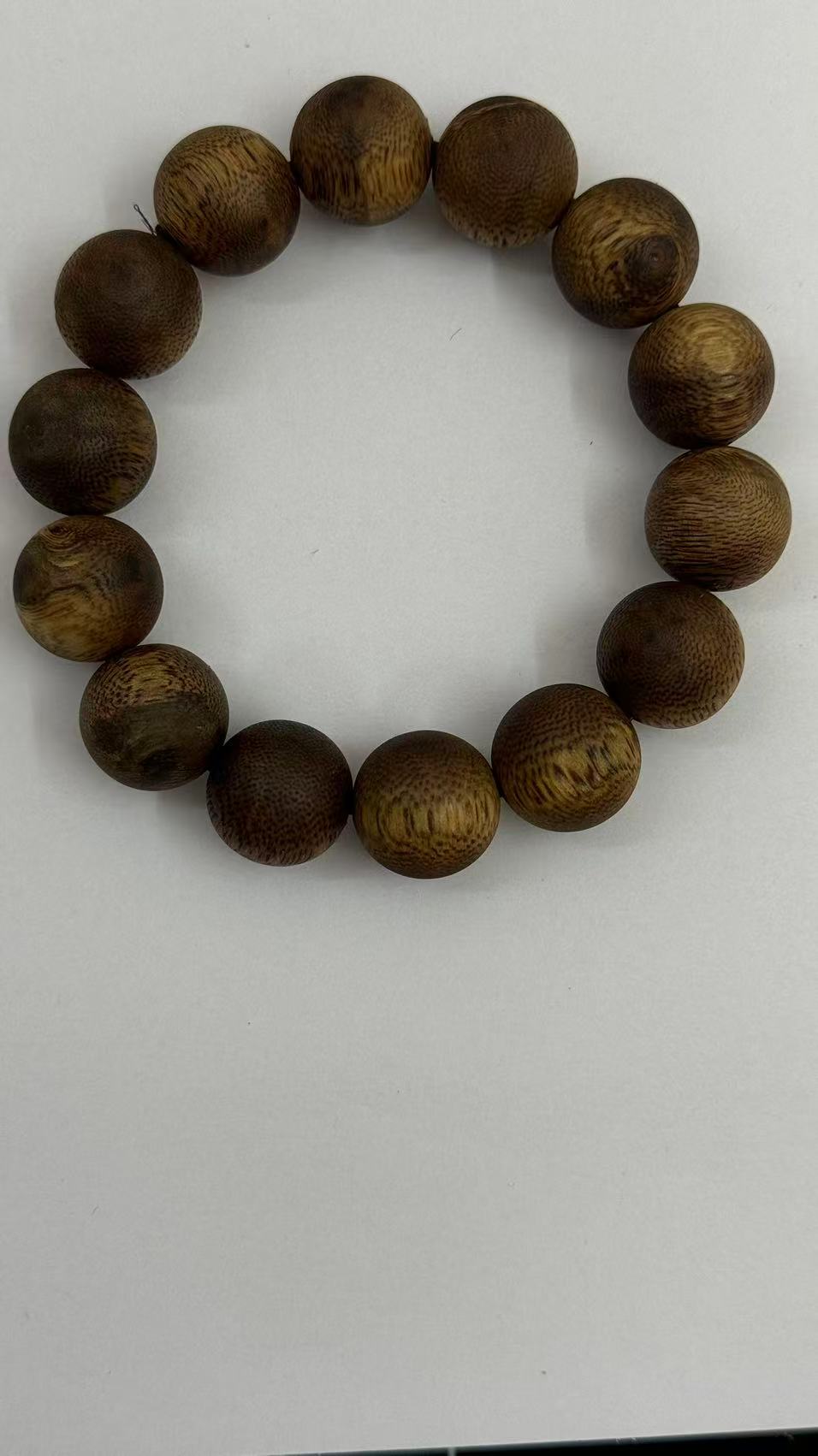 Wild agarwood wrist mala beads in honey and dark brown tones close up