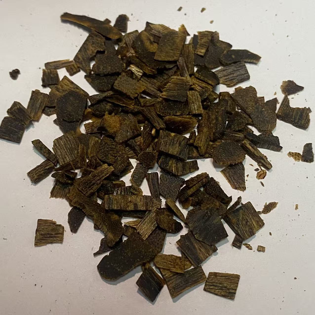 Dark agarwood chips cut into small squares for bakhoor burning