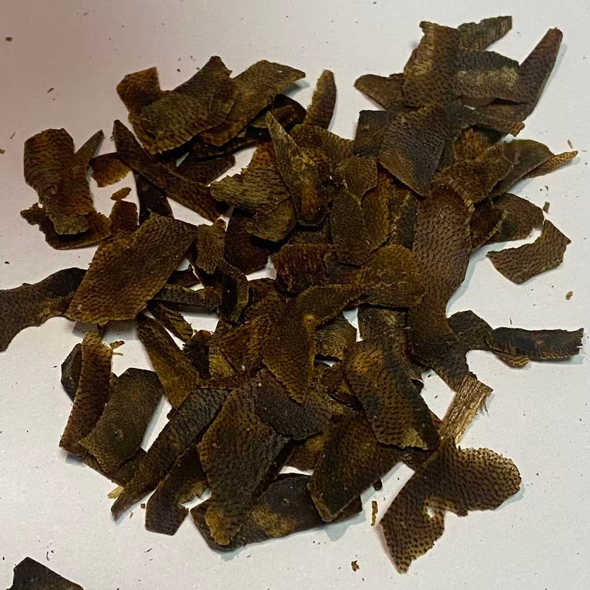 Close-up of dark kynam agarwood shavings showing rich oily resin texture
